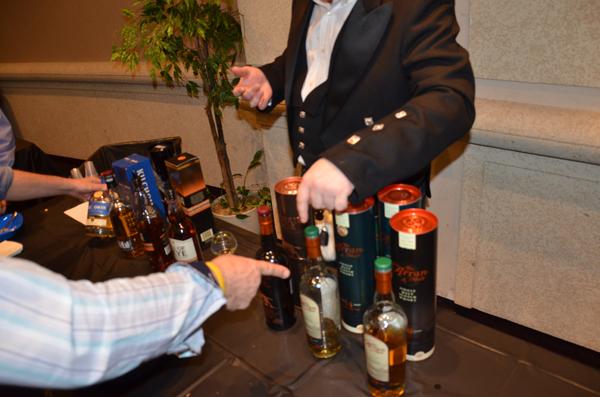 A Guys' Night Out attendee picks out his scotch from one of several tables