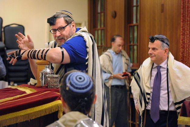 Right: Rabbi Barry Freundel of Kesher Israel in Georgetown wears tefillin for the  morning service. Photos by Lloyd Wolf