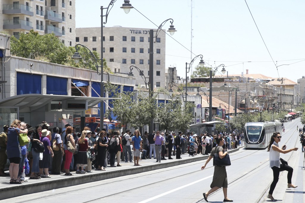 Passengers wait for the Jerusalem Light Rail train on Jaffa Road. 