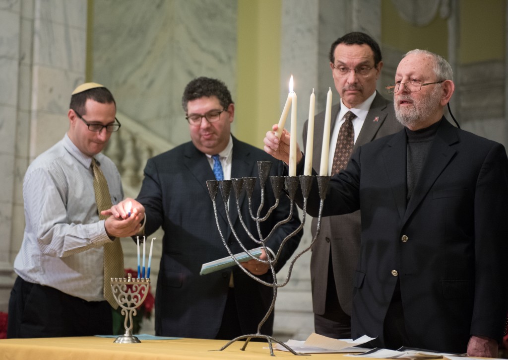 Rabbi Gerry Serotta, executive director of the InterFaith Conference of Metropolitan Washington, right, lights a menorah with Mayor Vincent Gray and other Jewish community leaders. 