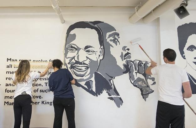 DCJCC’s Community Service Coordinator, Elena Frenkel (left), Leslie Dow (center) and Jared Lang (right) touch up the paint around a Martin Luther King Jr. mural at the Community for Creative Non-Violence, the largest homeless shelter in metro D.C., as part of the DCJCC’s MLK Day of Service on January 19. 