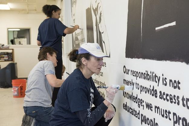  Sylvia Scherr touches up the paint around a James L. Farmer Jr. mural at the Community for Creative Non-Violence, the largest homeless shelter in metro D.C., as part of the DCJCC’s MLK Day of Service on January 19. 