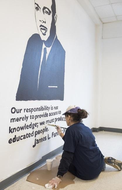  Sylvia Scherr touches up the paint around a James L. Farmer Jr. mural at the Community for Creative Non-Violence, the largest homeless shelter in metro D.C., as part of the DCJCC’s MLK Day of Service on January 19. 