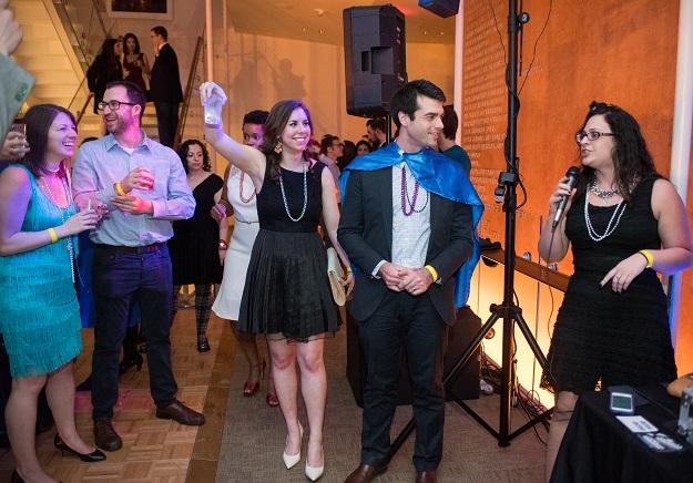 Tami Wolf, director of the DCJCC’s Entry Point DC program, thanks guests for coming to The DC Purim Bash at Shakespeare Theatre’s Sidney Harman Hall on March 7, while Emily Zeller raises her glass in a toast and Washington Hebrew Congregation Associate Rabbi Aaron Miller looks on. 