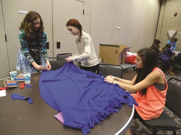 From left, BBYO members Margaret Devins, Leah Holzer and Sydney Weinstein make blankets for animals at Congregation Beth El in Bethesda.