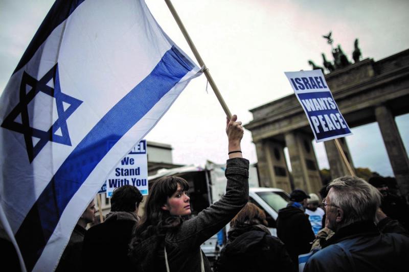 A demonstrator holds up an Israeli flag during Tuesday’s Berlin for Israel rally in front of the Brandenburg Gate in Berlin. The solidarity rally came one day prior to Israeli Prime Minister Benjamin Netanyahu's planned visit to the German capital. Photo by Michael Kappeler/Newscom