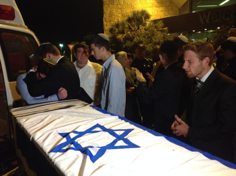 Friends and classmates gather around the coffin of slain yeshiva student Ezra Schwartz at Ben Gurion Airport before it is flown back to Massachusetts. Photo by Ben Sales