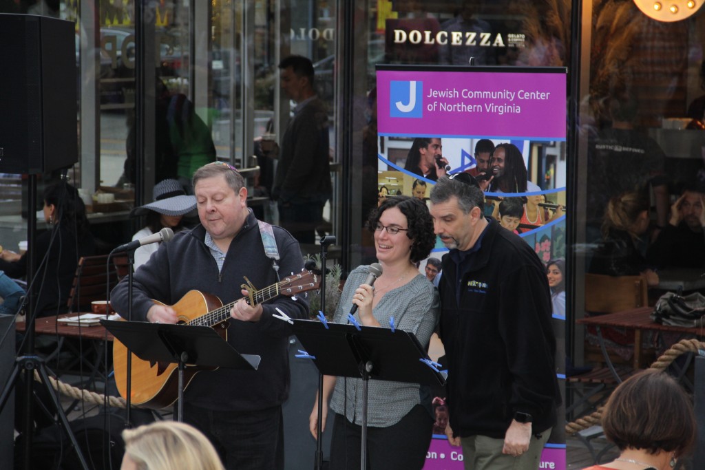 Cantors Allen Leider, Rachel Rhodes and Michael Shochet of Temple Rodef Shalom lead the crowd in song at a Community Menorah Lighting at Mosaic District on Dec. 13 in Fairfax.JCCNV Archives