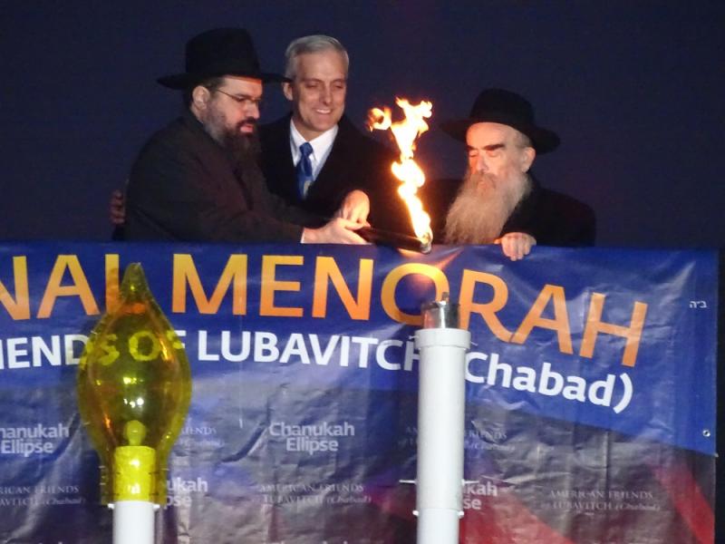 Rabbi Levi Shemtov, left, executive vice president of American Friends of Lubavitch, kindles the first Chanukah candle on the National Menorah. Watching are White House Chief of Staff Denis McDonough, center, and Rabbi Abraham Shemtov, national director of American Friends of Lubavitch.Photo by Josh Marks