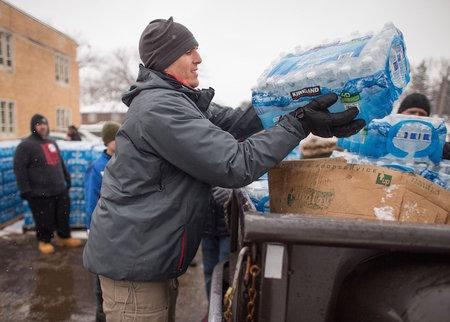 Volunteers load cases of water into waiting vehicles at a water distribution center last weekend in Flint, Mich. Photo by Geoff Robins/AFP/Getty Images via JTA 