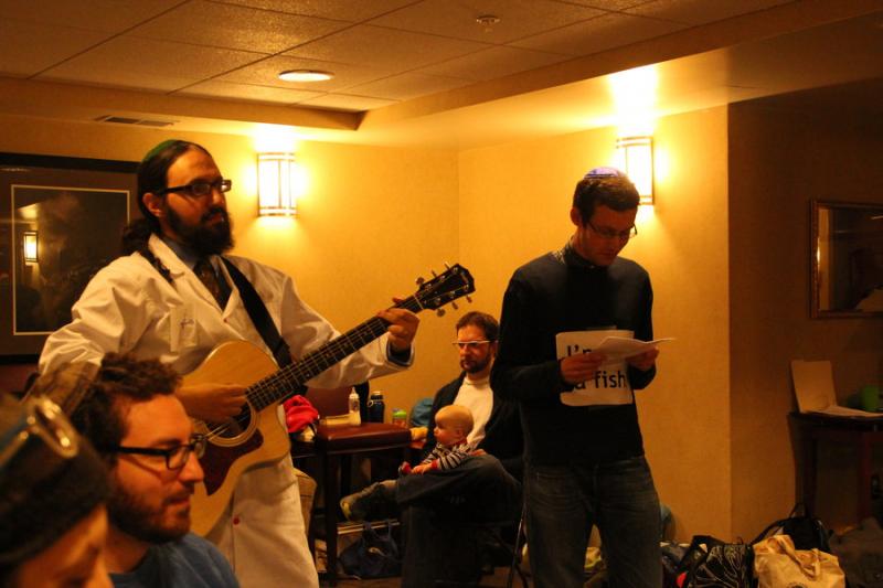 Ben Dreyfus, with guitar, and Michael Freiman, right, entertain Segulah Minyan members at their Purim party. Photos courtesy Segulah Minyan