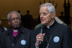Michael Curry (left), presiding bishop of the Episcopal Church of the United States, listens as Cardinal Donald Wuerl, archbishop of Washington, makes his remarks.