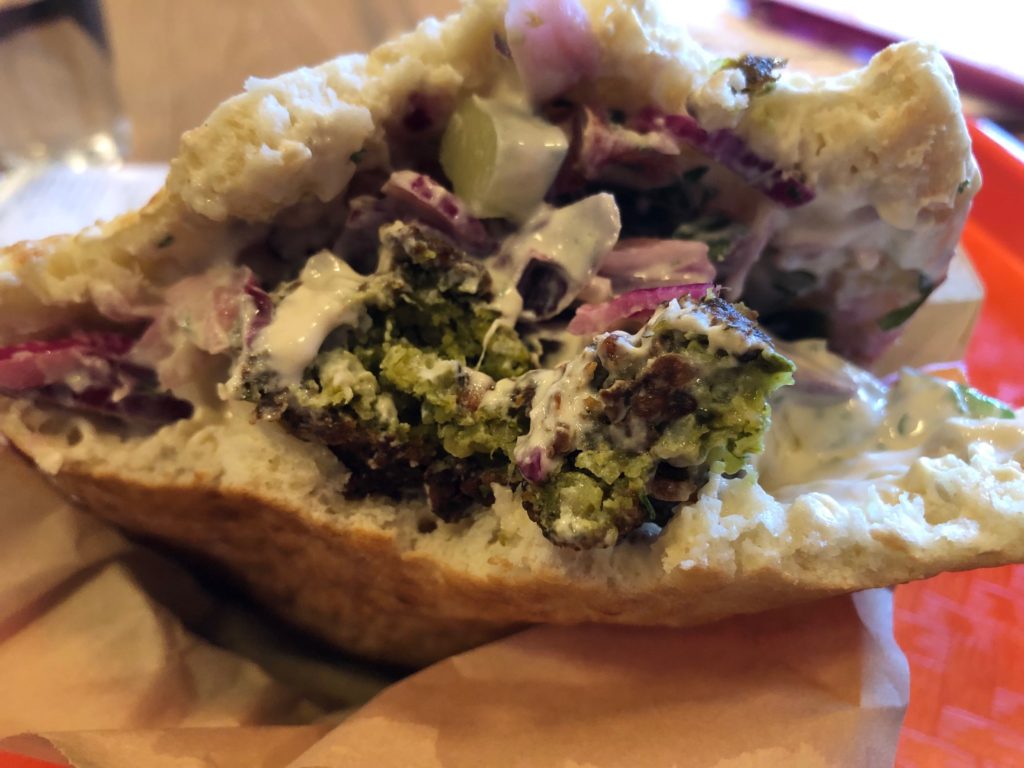 The inside of a green falafel pita